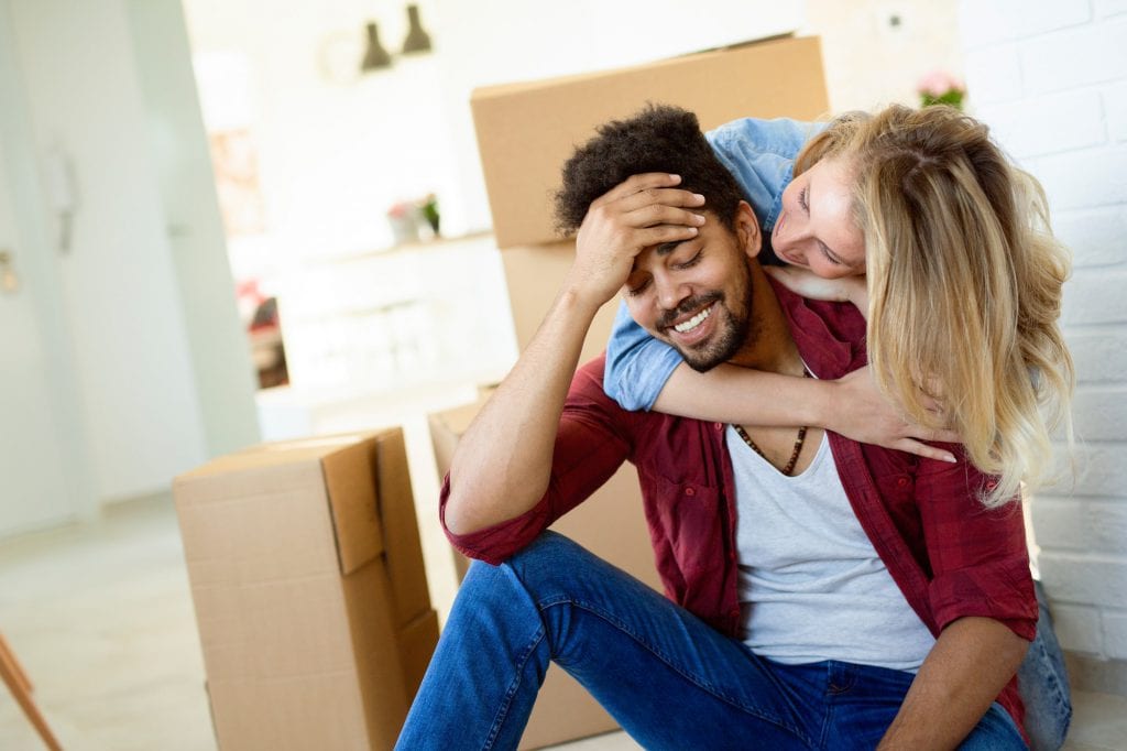 Tired couple with boxes moving into new home