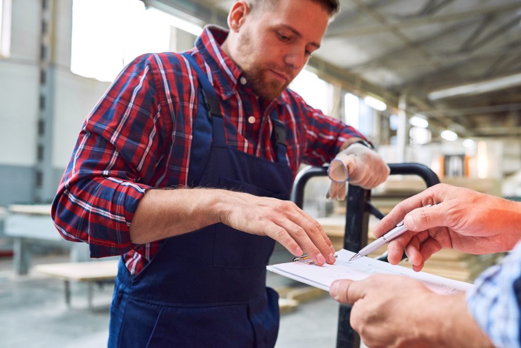 Worker Signing Shipments Order in Warehouse