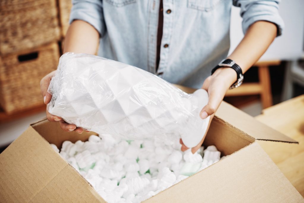 Woman packing vase in box